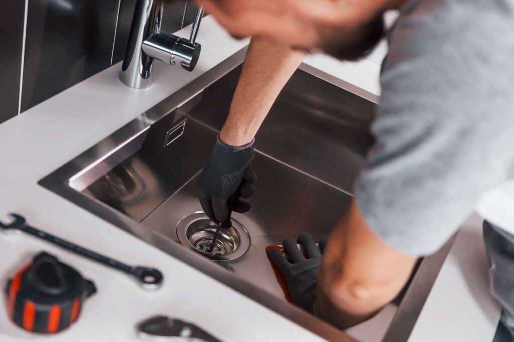 plumber cleaning a kitchen drain